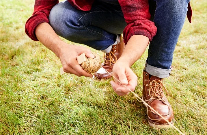 Person spannt Schnur auf Rasen